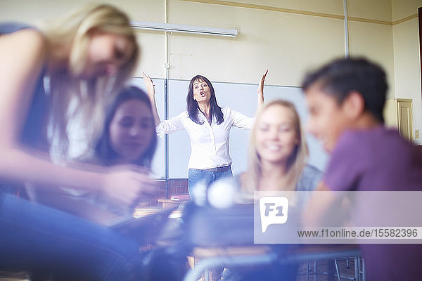 Frustrierte Lehrer und sprechende Schüler im Klassenzimmer