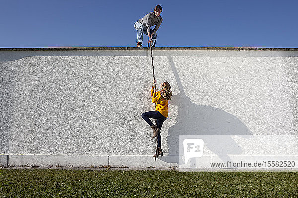 Germany  Bavaria  Munich  Young couple climbing wall