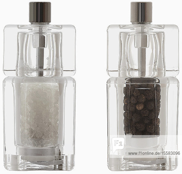 Salz- und Pfeffermühle aus Plexiglas vor weißem Hintergrund  Nahaufnahme