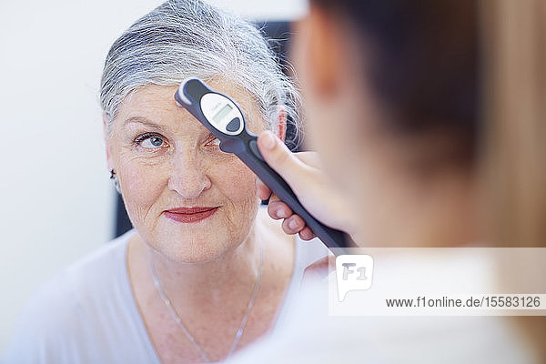 Augenarzt untersucht das Sehvermögen einer älteren Frau
