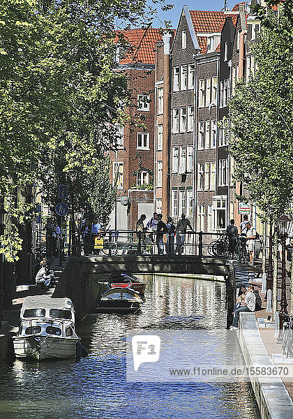 Niederlande  Amsterdam  Menschen auf kleiner Brücke über den Kanal
