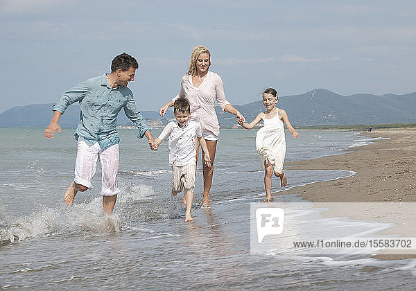 Spanien  Familie am Strand laufen