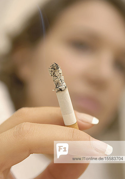 Nahaufnahme des Fingers einer Frau mit verbrannter Zigarette