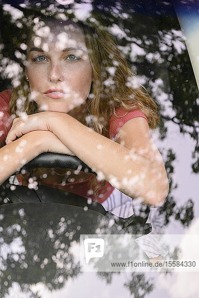 View through windscreen of young woman in car