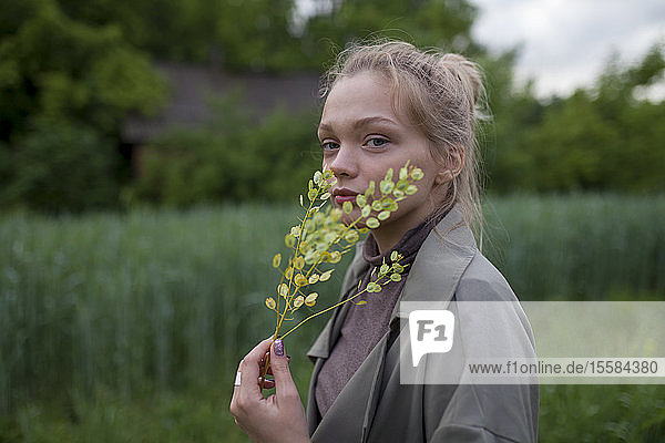 Junge Frau hält grüne Zweige