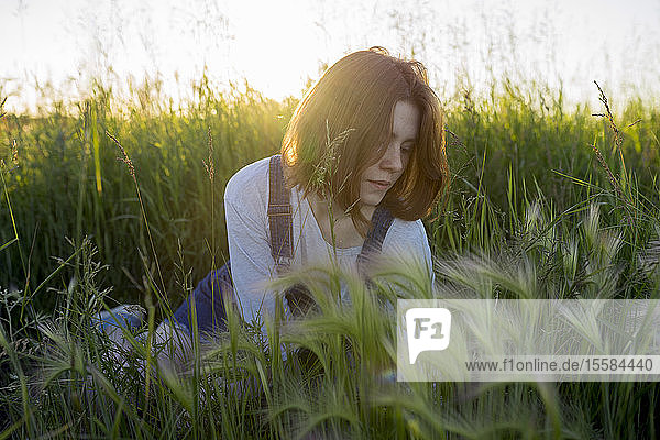 Young woman sitting in wheat field