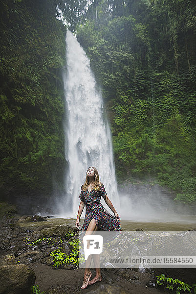 Frau an einem Wasserfall in Bali  Indonesien