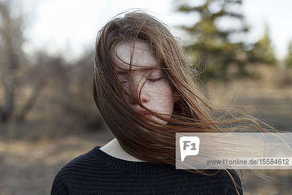 Portrait of windswept teenage girl with her eyes closed