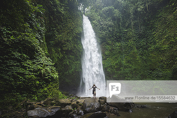 Frau an einem Wasserfall in Bali  Indonesien