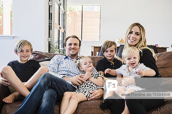 Lächelnde Familie auf Ledersofa sitzend