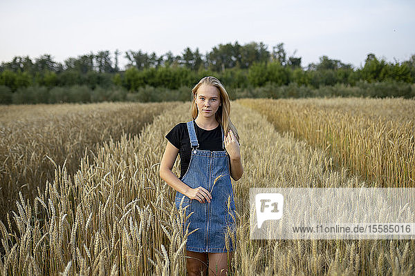 Junge Frau im Overall in einem Weizenfeld
