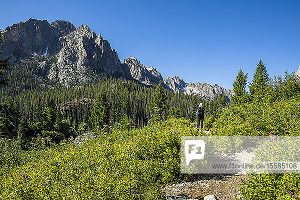 Woman hiking by Sawtooth Mountains in Stanley  Idaho  USA