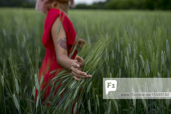 Frau in rotem Kleid in einem Weizenfeld