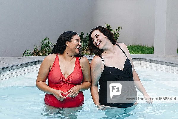 Zwei mittelgroße erwachsene Frauen stehen zusammen lachend im Freibad  Kapstadt  Südafrika