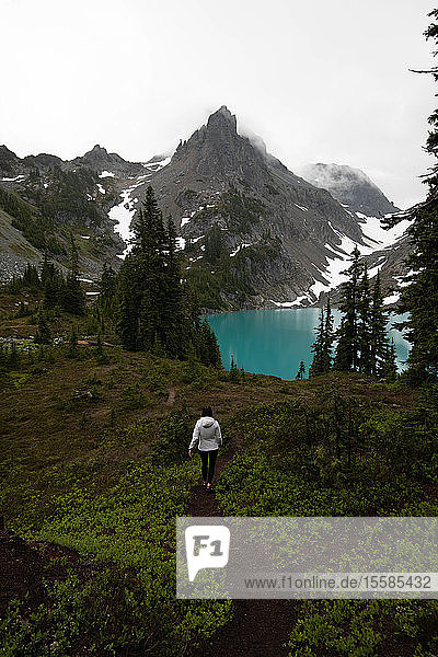 Tourist exploring wilderness  Alpine Blue Lake  Washington  USA