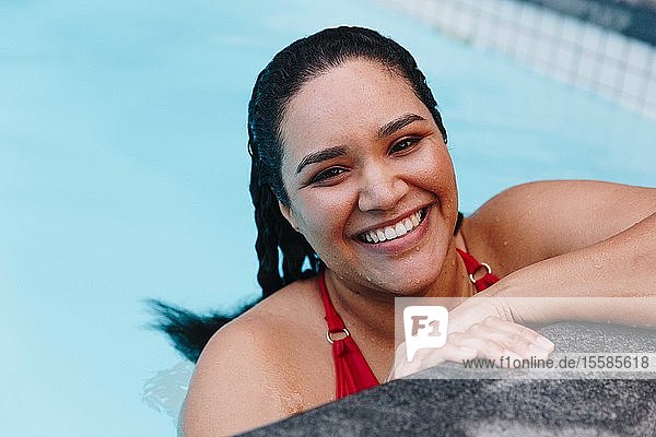 Mittelgroße erwachsene Frau mit nassem Haar  die am Swimmingpool im Freien ruht  Kopf- und Schulterporträt  Kapstadt  Südafrika