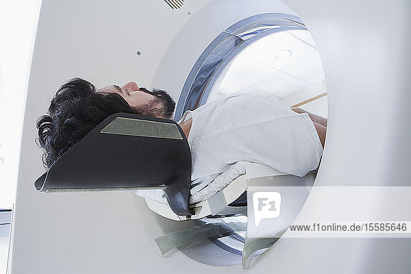 Junger männlicher Patient mit einem CT-Scan in der radiologischen Abteilung Niedrigwinkelansicht