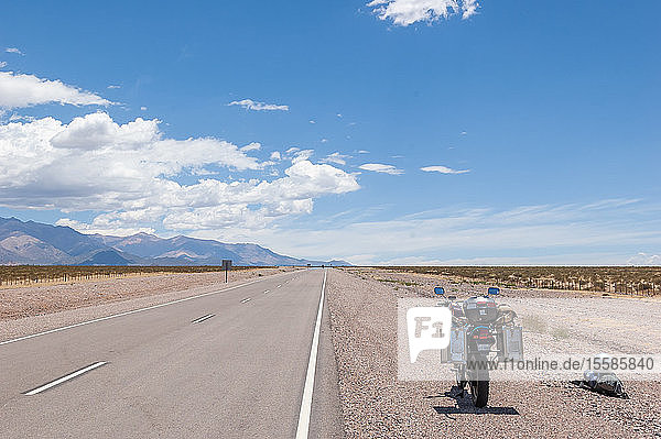 Landschaft mit am ländlichen Straßenrand abgestelltem Motorrad Mendoza Argentinien