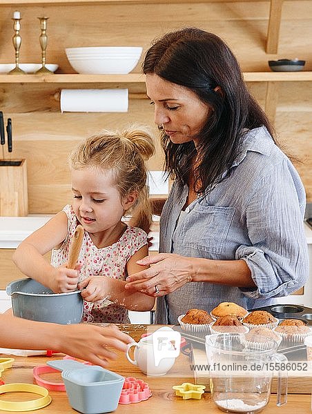 Mutter und Kinder backen Cupcakes in der Küche