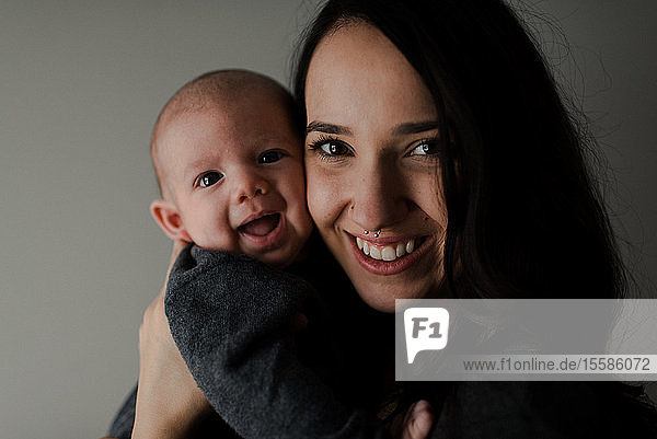 Junge Frau hält Baby Sohn  Kopf und Schulterporträt