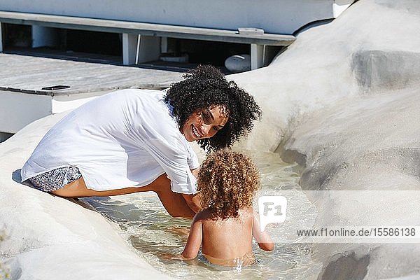 Mother and daughter playing in manmade pool