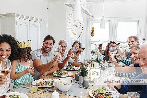 Family toasting wine at dining table in home party