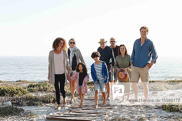Achtköpfige Familie geht am Strand spazieren
