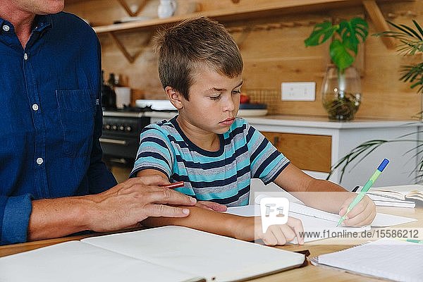Vater hilft Sohn bei den Hausaufgaben zu Hause