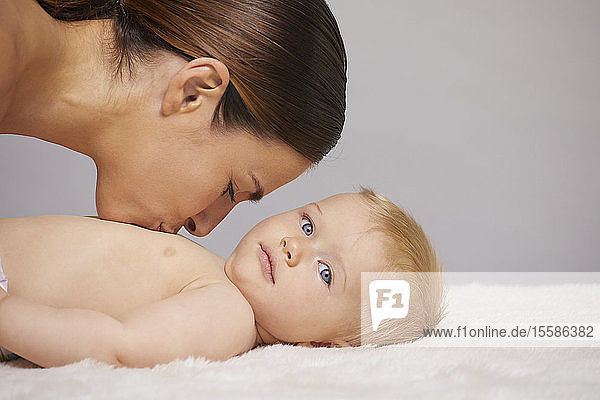 Mother kissing baby on chest