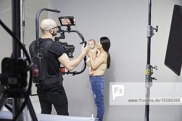 Photographer taking portrait of mother and baby