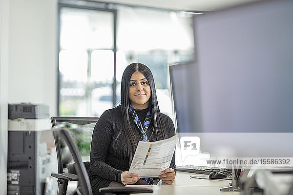 Portrait of female apprentice service advisor in car dealership