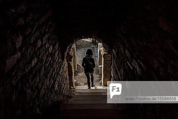 Frau  die in einem Steingebäude eine Treppe hinuntergeht  Izmir  Türkei