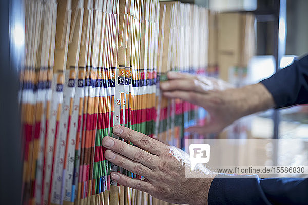 Close up of worker selecting job bags in print factory