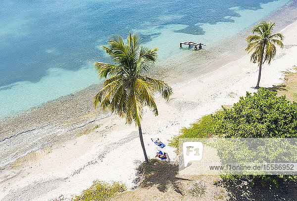 Mann und Frau entspannen sich am palmengesäumten Strand  Luftaufnahme einer Drohne  Karibisches Meer  Antillen  Westindische Inseln  Karibik