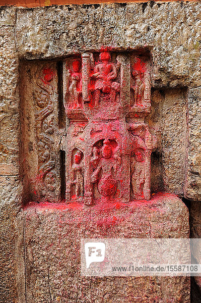 450 Jahre alte Schnitzereien von Göttern  die von Hindu-Pilgern mit rotem Pulver gesegnet wurden  in den Wänden des Kamakhya-Tempels  Gauhati  Assam  Indien