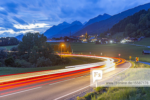 Blick auf eine kurvenreiche Straße und Wegbeleuchtung in der Abenddämmerung bei Oberhaus  Steiermark  Österreich