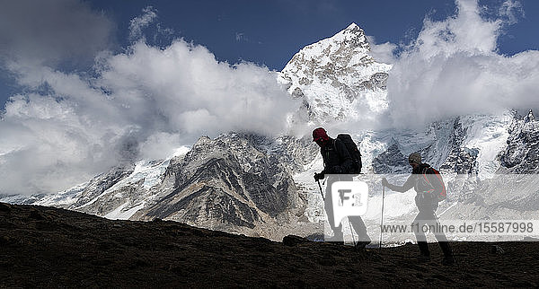 Man and woman trekking with Mt Everest Nuptse and Kala Patthar in background Himalayas Solo Khumbu Nepal