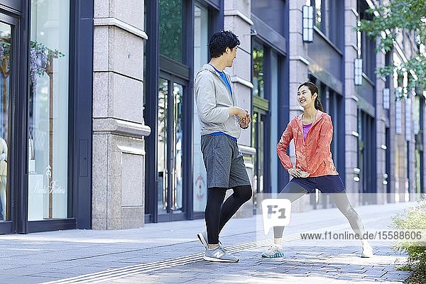 Young Japanese couple running downtown Tokyo