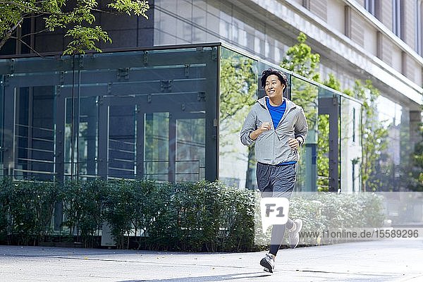 Young Japanese man running downtown Tokyo
