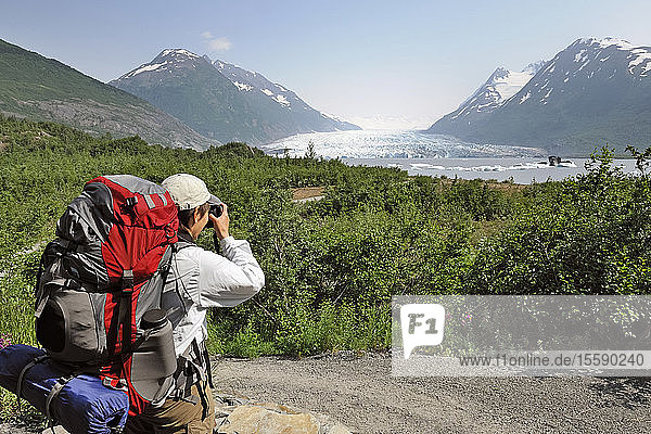 Weiblicher Wanderer hält für ein Foto entlang des Pfades zum Spencer Glacier an  Süd-Zentral-Alaska