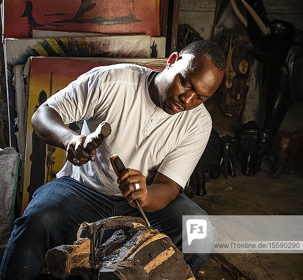 Man carving a mask with a chisel; Arusha  Arusha Region  Tanzania