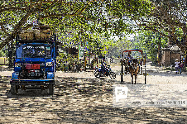 Verschiedene Verkehrsmittel auf einer Straße mit einem Lastwagen  einem Motorrad  einem Pferd und einer Kutsche; Bagan  Region Mandalay  Myanmar