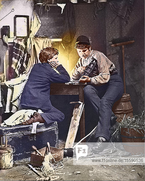 Diapositiv mit Laterna Magica  um 1880  viktorianisch/edwardianisch  Sozialgeschichte. Fotografie mit dem Titel Der Bootsbauer   zwei Jungen sitzen neben einer Lampe und schnitzen ein Modellboot  handkoloriert