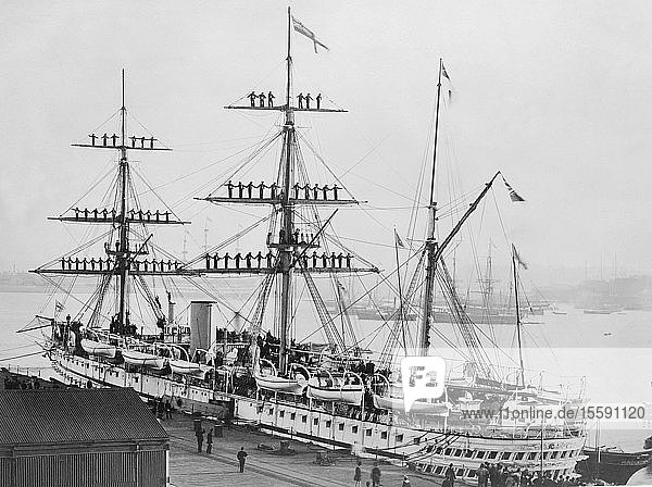 Negative circa 1900  Victorian era. HMS Jumna in 1880  a Euphrates-class troopship launched at Palmers Shipbuilding and Iron Company in Hebburn on 24 September 1866. The shipâ€™s company are manning the rigging as the Royal Yacht Victoria and Albert comes alongside  just below the Jumnaâ€™s stern. Aboard the yacht was the Prince of Wales  later Edward VII  who was returning from an official visit. Restored and hand coloured in Photoshop; Hebburn  Tyne and Wear  England