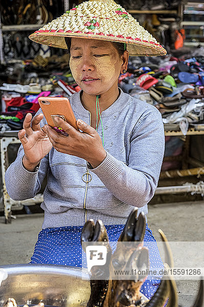 Frau mit ihrem Smartphone auf dem Markt; Lashio  Shan-Staat  Myanmar