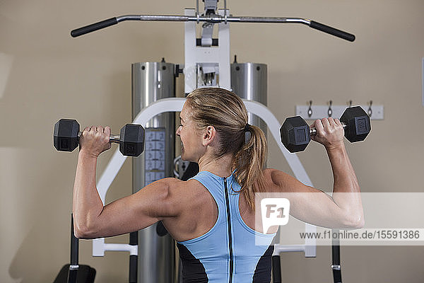 Woman exercising with dumbbells in a gym