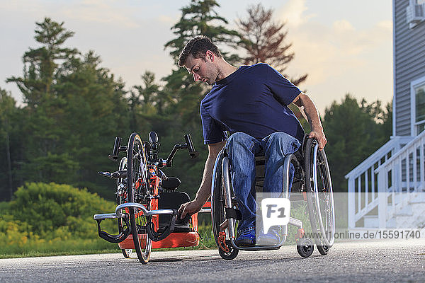 Ein querschnittsgelähmter Mann in seinem Rollstuhl mit seinem speziell angefertigten adaptiven Handbike