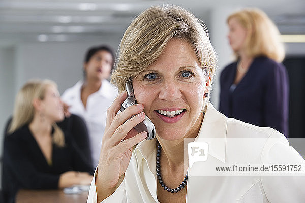 A smiling business woman using a cellphone.