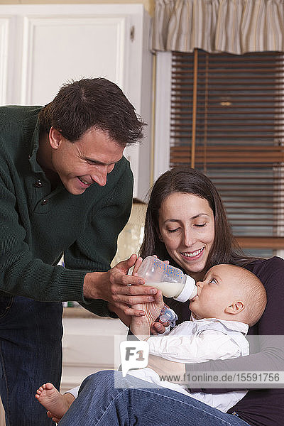 Parents feeding their son with bottle