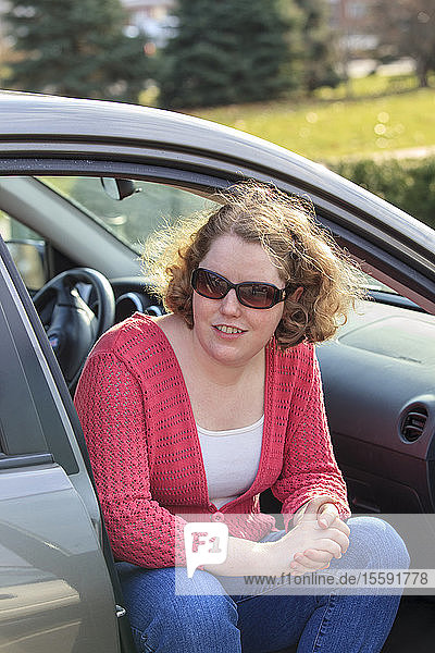 Young woman with Autism sitting in her car